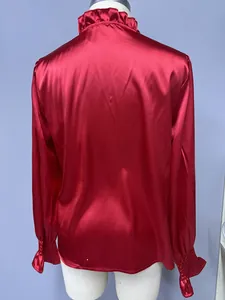 Back view of an elegant red satin long sleeve blouse with ruffled collar and smocked cuffs