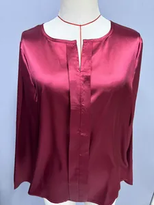 Primo piano di un'elegante camicetta di raso bordeaux con moderno dettaglio dello scollo a V