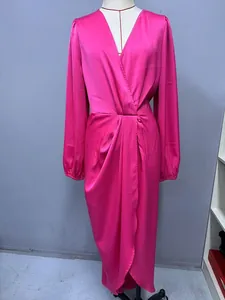 Detail of hot pink satin dress featuring lantern sleeves and a wrap V-neckline.