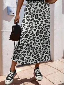 Detail der Satin-Midirock mit Leopardenmuster, kombiniert mit schwarzen Sneakern