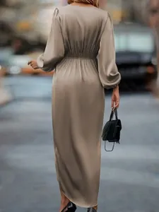 Detail view of a taupe satin maxi dress with lantern sleeves and elastic waist.