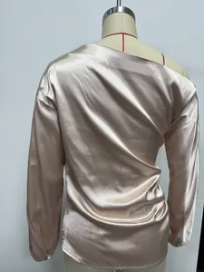 Back view of elegant champagne satin long-sleeved blouse with slanted shoulder design