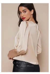 Vista posterior detallada de una elegante blusa de satén champán con mangas abullonadas