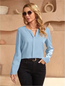 Elegante camicetta a maniche lunghe in raso azzurro da donna in un ambiente minimale