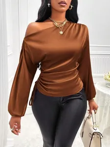 Detail view of brown satin asymmetrical blouse with one-shoulder design and ruched side
