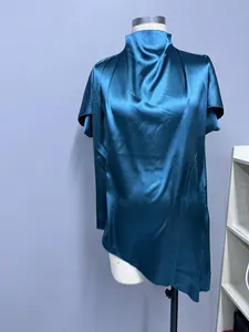 Detailansicht einer dunkelblauen Satinbluse mit asymmetrischem Saum und elegantem Faltenwurf