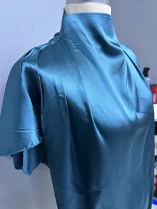 Detailaufnahme einer eleganten petrolfarbenen Satinbluse mit plissiertem Kragen