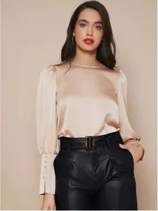 Elegante blusa de satén champán con mangas largas de farol y puños de botones decorativos