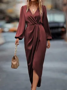 Detailed view of maroon satin dress featuring lantern sleeves and a wrap twist waist