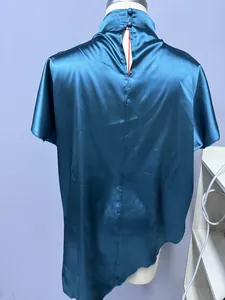 Rückansicht der petrolfarbenen Satinbluse mit Stehkragenknöpfen und asymmetrischem Saum