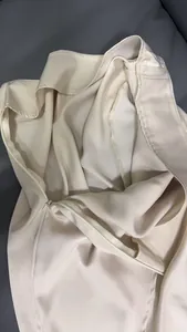 Detailed macro view showing the invisible zipper on a champagne beige satin skirt.