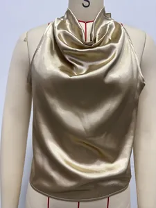 Detail of a luxury champagne gold satin halter top featuring a soft cowl neckline