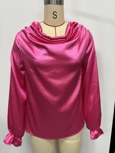 Detail showing pink satin blouse with cowl neck and ruffled cuffs on mannequin stand