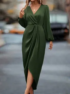 Full length view of a dark green satin wrap dress with lantern sleeves and V-neck