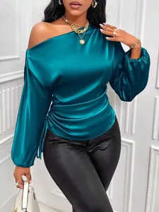 Detail showing teal satin asymmetrical one-shoulder blouse with lantern sleeves