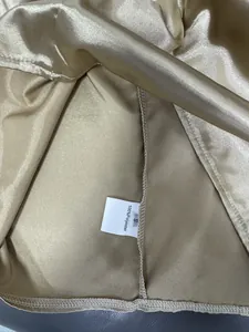 Detail of 100% polyester satin shirt label showing material and size S.