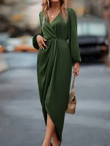 Detail view of an elegant olive green satin dress with lantern sleeves and split hem