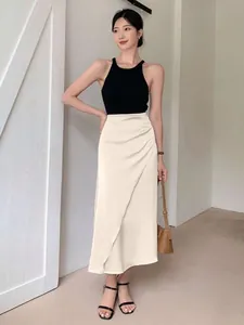 Elegant cream satin midi skirt with side drape detail worn by a stylish Asian model