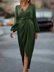 Elegant dark green satin wrap dress featuring lantern sleeves and an irregular split hem detail