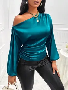 Detailed view of teal satin blouse featuring asymmetrical neck and lantern sleeves