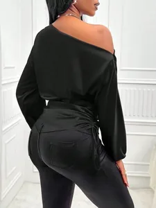 Back detail of elegant black satin blouse with asymmetrical neck and ruched side.