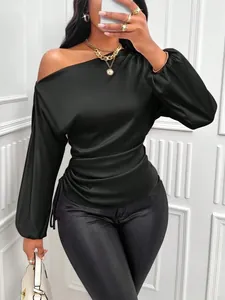 Detail of black satin blouse featuring asymmetrical neckline and pleated waist design.