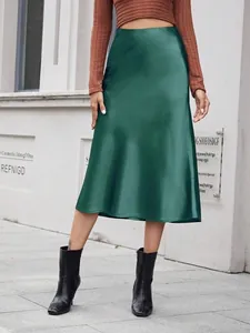 Vue d'ensemble d'une jupe midi en satin vert foncé à taille haute sur un modèle
