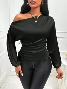 Close-up of black satin long sleeve top with asymmetric one shoulder neck and ruched waist