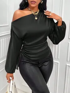 Detail of black satin blouse featuring an asymmetric oblique neck and ruched sides.