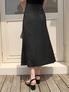 Detailed rear view of an elegant high-waisted black satin midi skirt with smooth texture