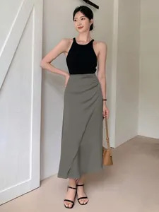 Elegant olive green satin wrap midi skirt paired with black halter top for a sleek look.