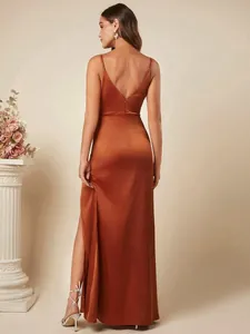 Elegante roestkleurige satijnen maxi-jurk met diepe V-hals op de rug en spaghettibandjes.