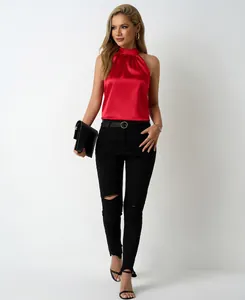 Red satin halter neck top paired with black distressed skinny jeans