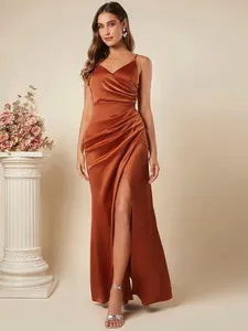 Detailweergave van de elegante geplooide taille en hoge split van de koperen satijnen jurk