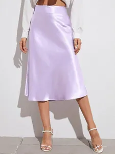 Détail montrant la texture brillante d'une jupe midi en satin taille haute lavande
