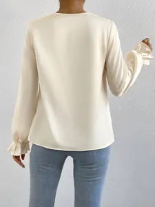 Back view of elegant ivory satin long-sleeved blouse featuring stylish ruffled cuffs