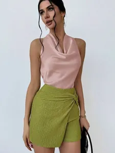 Detail of elegant sleeveless pink satin cowl neck blouse paired with green textured skirt