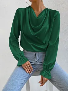 Close-up showing the shimmering dark green satin fabric and ruffled cuff design
