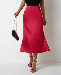 Détail d'une élégante jupe midi sirène en satin rouge avec une finition satinée lisse.