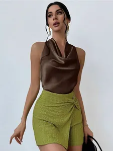 Close-up of a elegant brown satin halter top and green textured mini skirt on a model