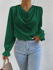 Detail of dark green satin blouse with elegant draped neckline and ruffled cuffs