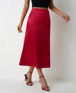 Élégante jupe midi en satin rouge à taille haute portée par un mannequin en studio