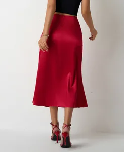 Vue arrière élégante d'une jupe mi-longue en satin rouge avec une texture lisse