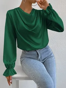Macro view of green satin blouse with elegant cowl neck and ruffled cuffs detail.