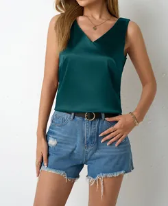 Close-up view of elegant emerald green satin V-neck tank top worn by model in a studio