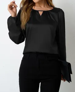 Detail einer schwarzen Satinbluse mit elegantem plissiertem Ausschnitt