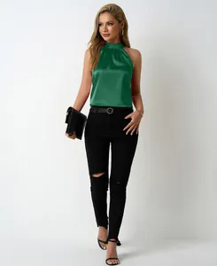 Elegant green satin halter neck top for women paired with black ripped jeans.