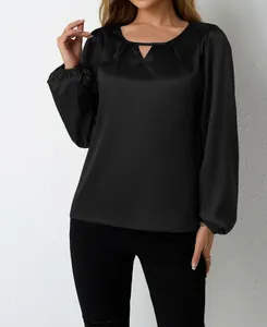 Detailaufnahme einer eleganten schwarzen Satinbluse mit langen Ärmeln und Falten-V-Ausschnitt