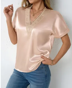 Detailed view of elegant V-neck satin blouse with intricate lace trim in champagne finish