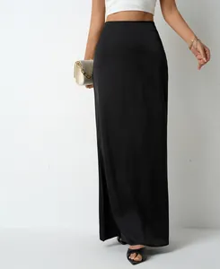Elegant black satin maxi skirt for women shown on model with chic quilted handbag